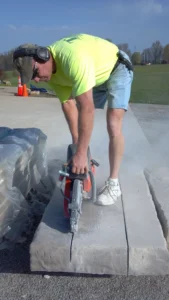 a man cutting a slab of stone with a machine
